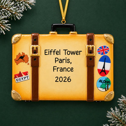 Personalized tan travel suitcase christmas ornament on a dark green pine background