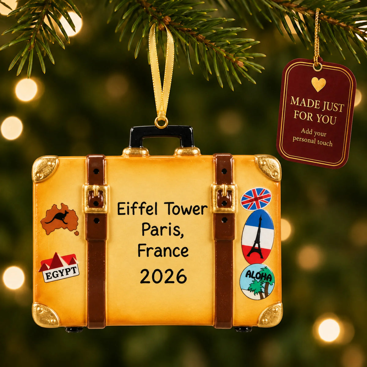 Tan travel suitcase christmas ornament hanging on a lit Christmas tree with a Made Just For You gift tag