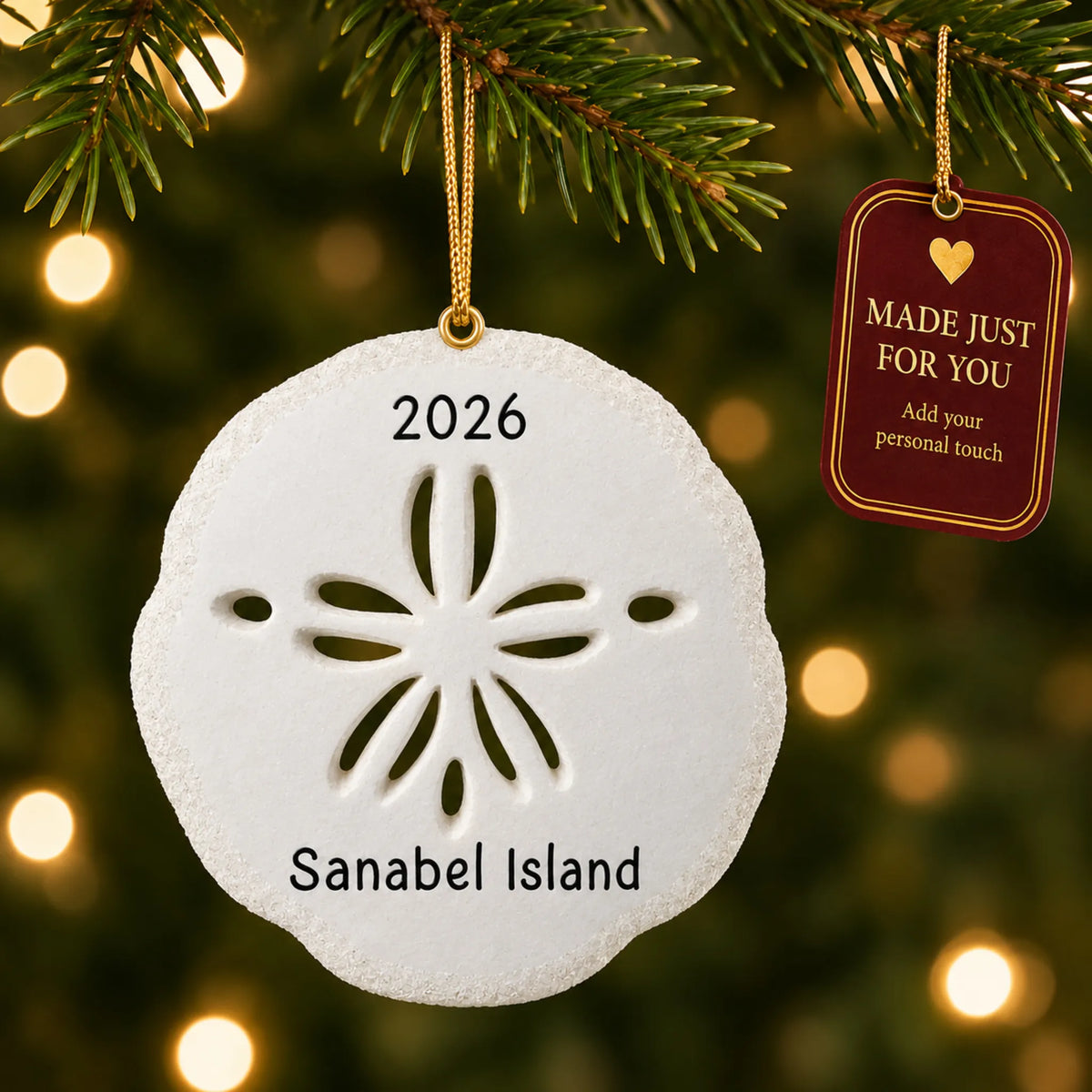 Sand dollar christmas ornament hanging on a lit Christmas tree with a Made Just For You gift tag