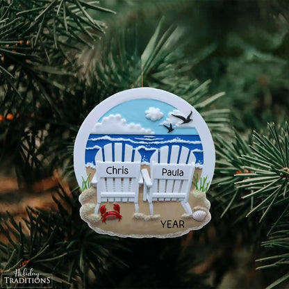 Decorative ornament with beach scene and personalized names on a Christmas tree.