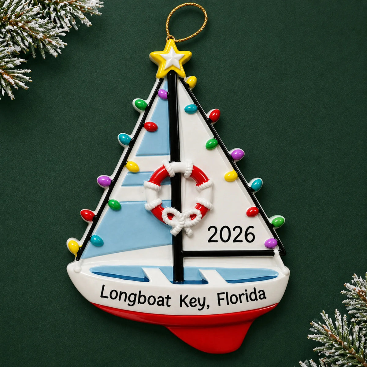 Personalized lighted sailboat christmas ornament on a dark green pine background