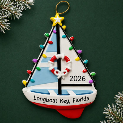 Personalized lighted sailboat christmas ornament on a dark green pine background