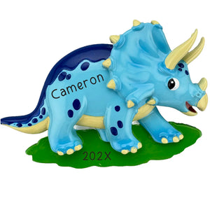 Personalized blue triceratops Christmas ornament with three yellow horns and navy spots, custom engraved with a name and year