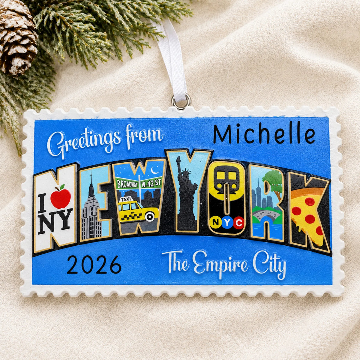 Personalized New York City postcard christmas ornament laid on a soft white knit blanket