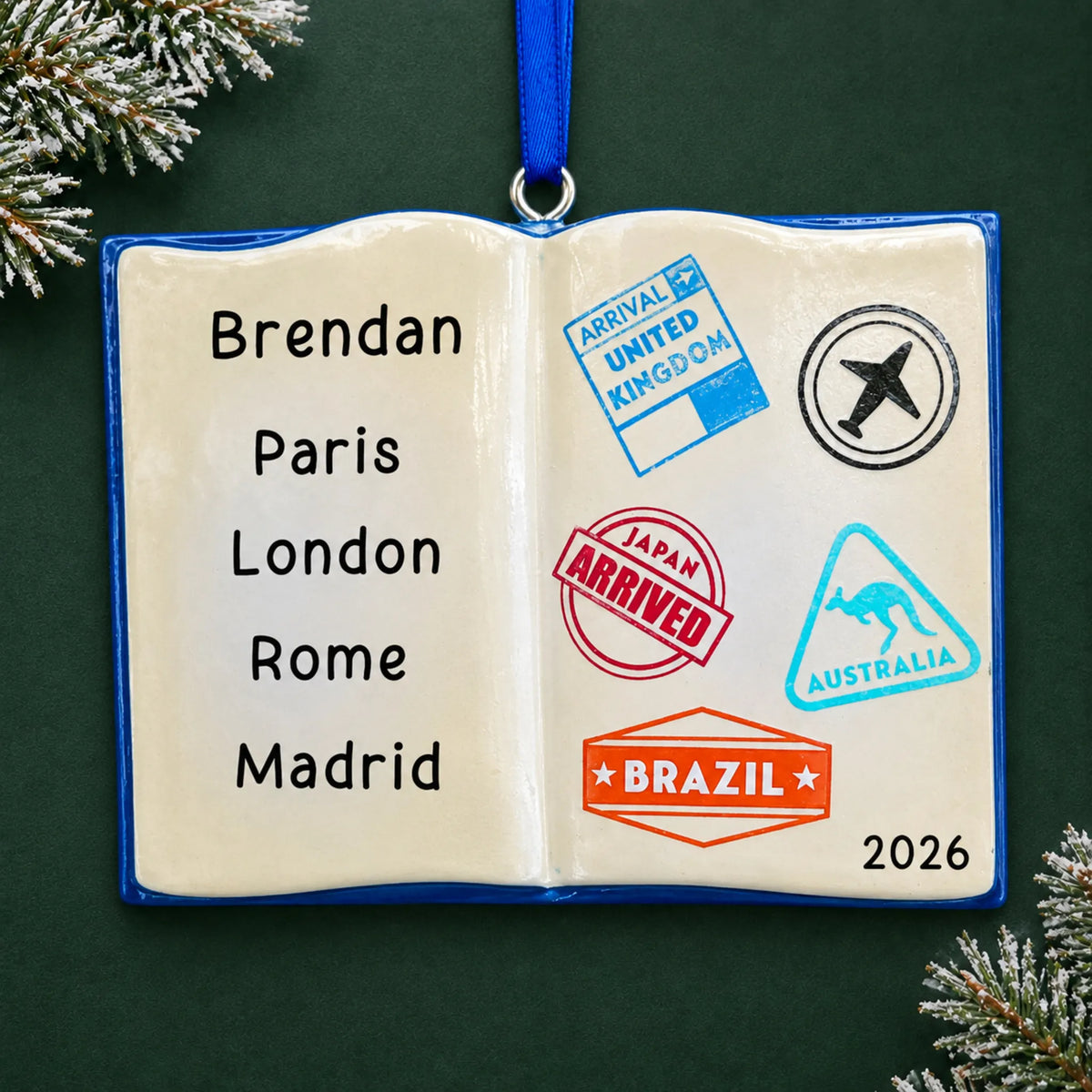 Personalized travel passport christmas ornament, an open travel passport with country stamps, on a dark green pine background
