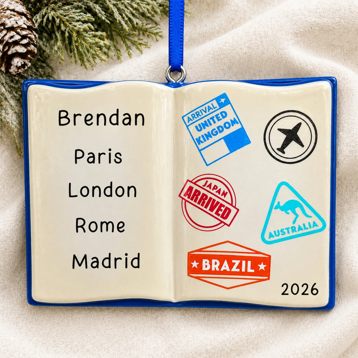 Personalized travel passport christmas ornament laid on a soft white knit blanket