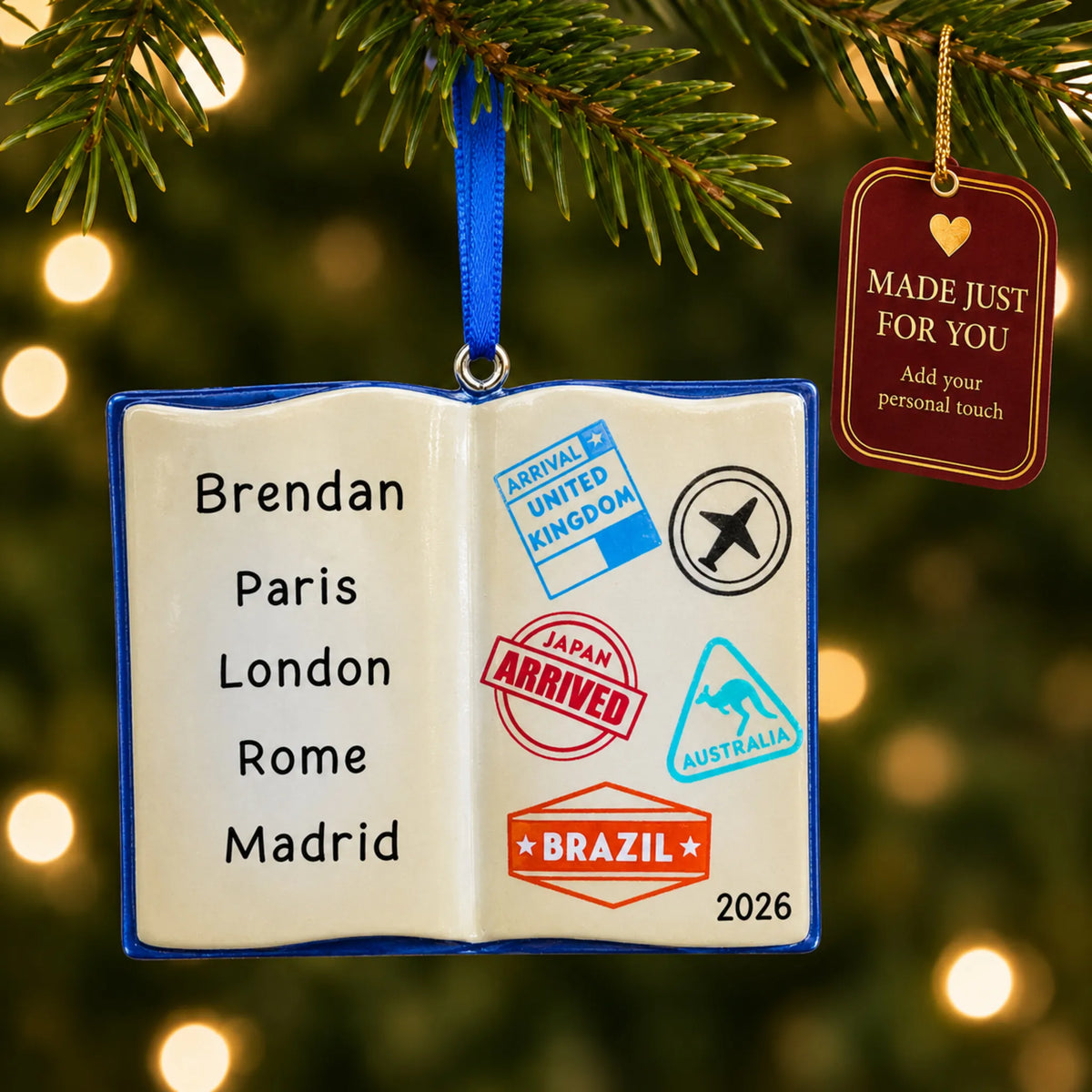 Travel passport christmas ornament hanging on a lit Christmas tree with a Made Just For You gift tag