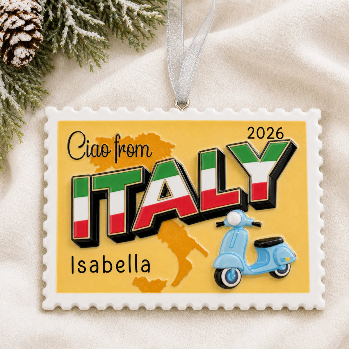 Personalized Italy postcard christmas ornament laid on a soft white knit blanket