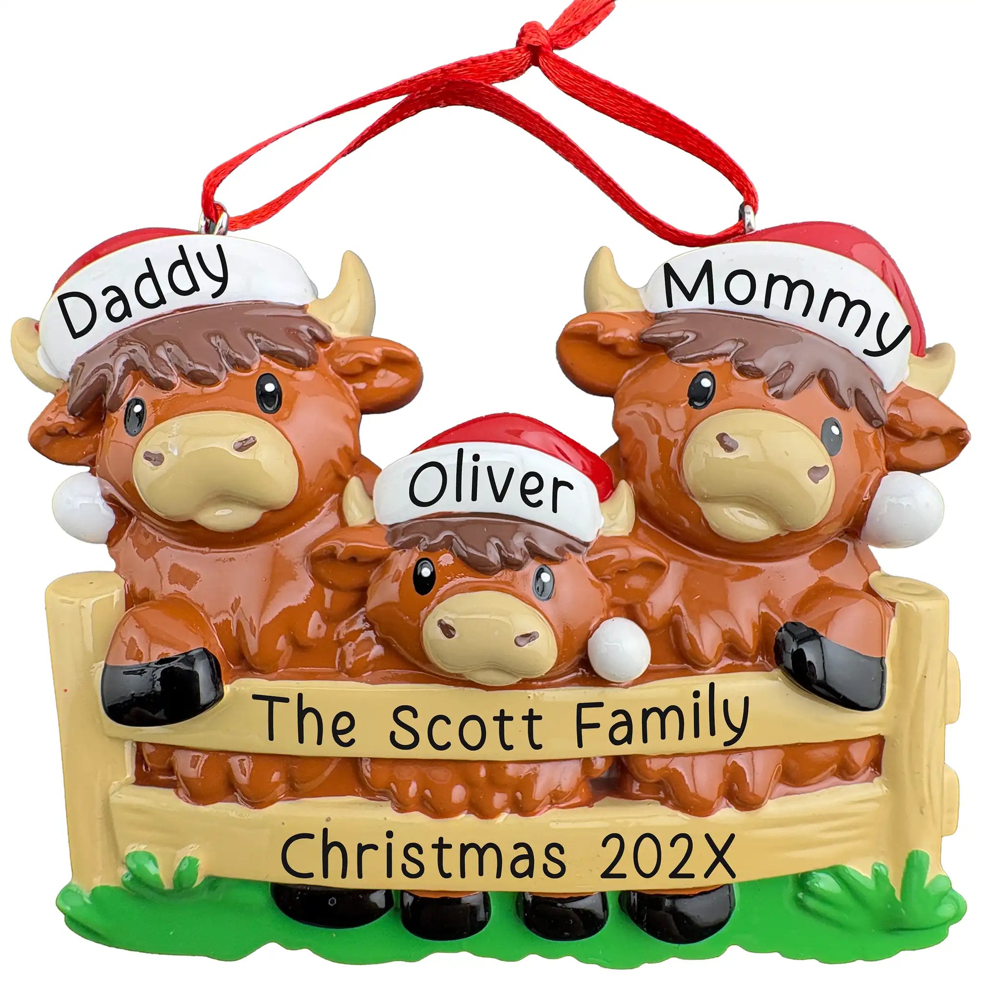 Personalized Highland Cow family of 3 Christmas ornament, two cows and a calf in Santa hats behind a fence, names engraved on hat brims with family name and year on the rails