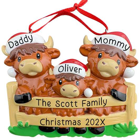 Personalized Highland Cow family of 3 Christmas ornament, two cows and a calf in Santa hats behind a fence, names engraved on hat brims with family name and year on the rails