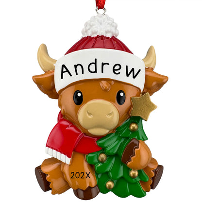 Personalized highland cow ornament, baby cow in a red pom hat and scarf hugging a Christmas tree, laser engraved with a name and year