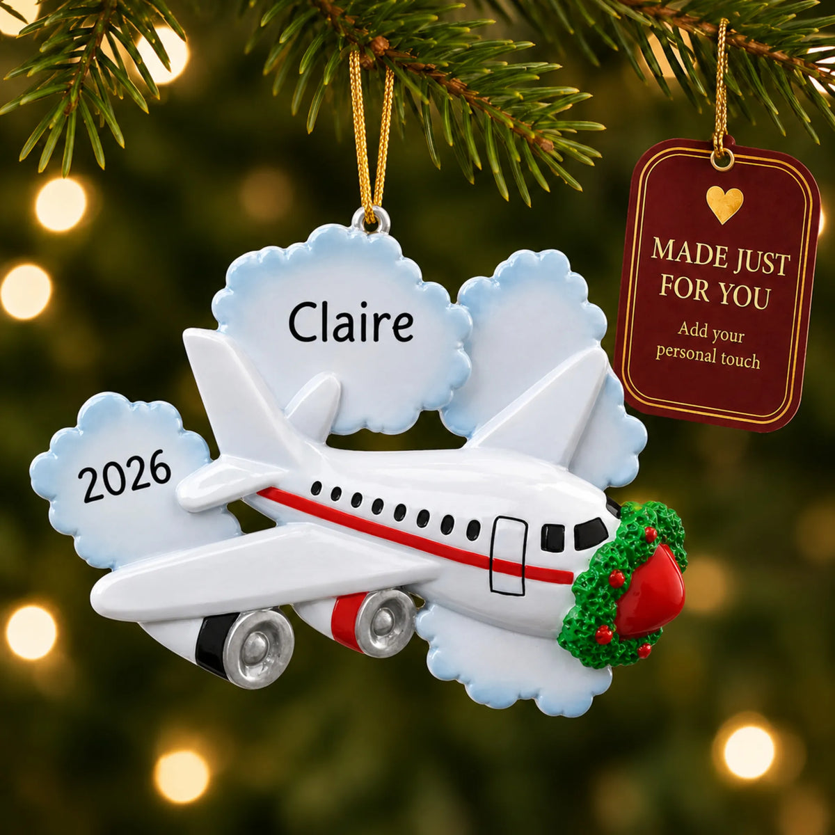 Jet airplane travel christmas ornament hanging on a lit Christmas tree with a Made Just For You gift tag