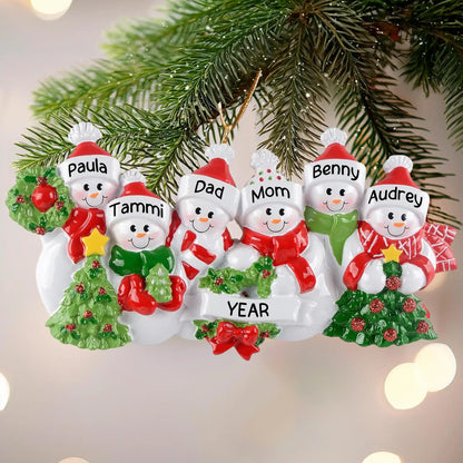 Personalized snowman family ornament with names on a Christmas tree.