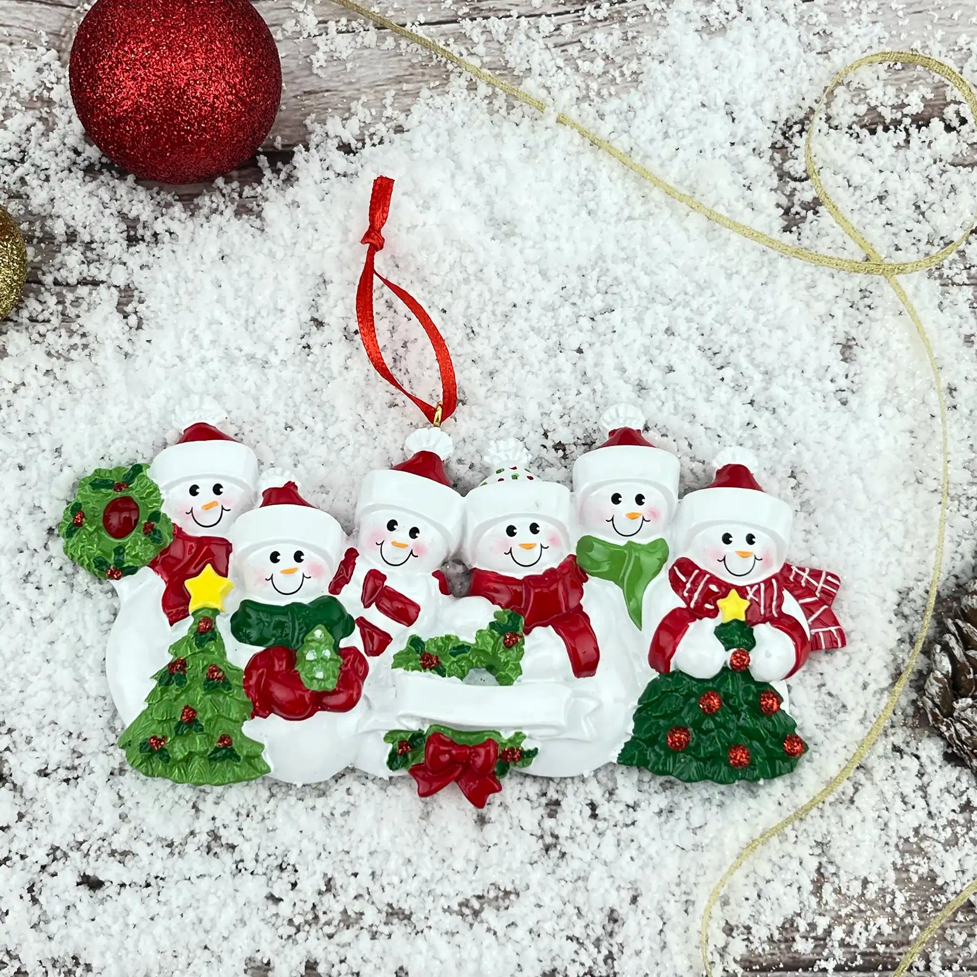 Decorative Christmas ornament of snowmen with a wreath on a snowy background