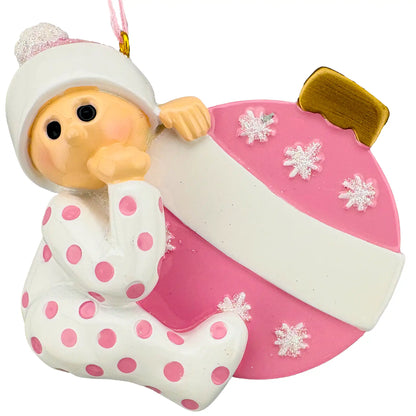 Baby girl personalized Christmas ornament shown blank, baby in pink polka dot pajamas with a pink ornament ball and empty banner
