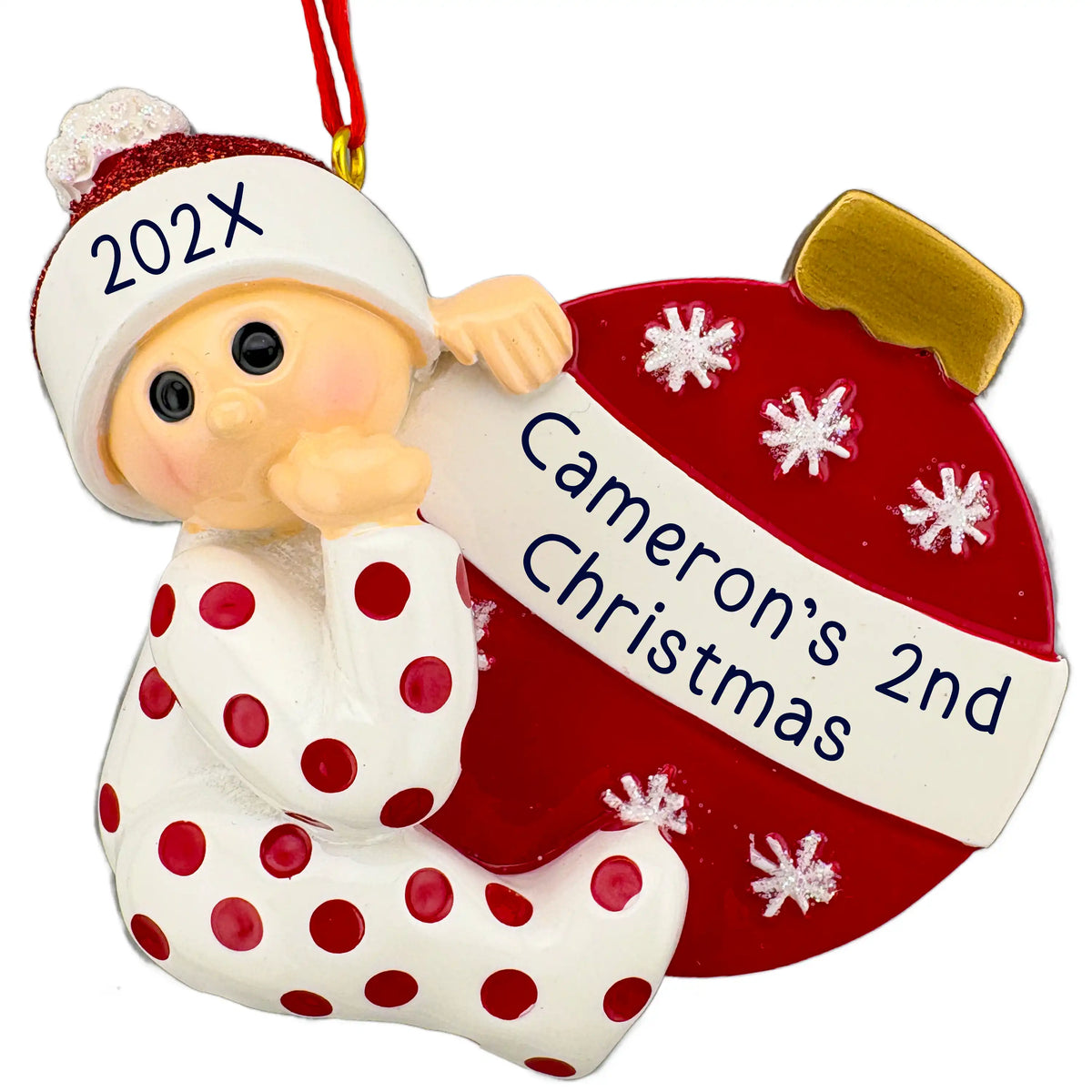 Personalized baby Christmas ornament in red, baby in polka dot pajamas hugging a red ornament ball with a laser engraved two line banner