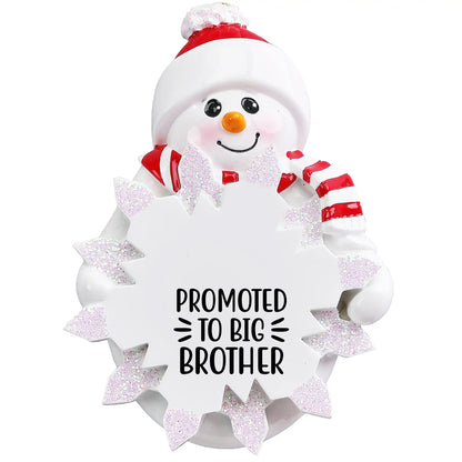 Personalized snowman ornament engraved with “Promoted to Big Brother,” featuring red hat and scarf with glitter snowflake customized with name and year.