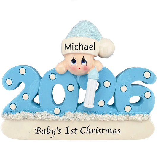 A blue 2026 Baby’s 1st Christmas ornament featuring a smiling baby in a glittery hat holding a bottle.