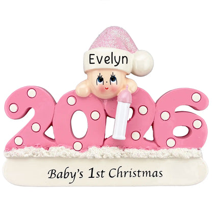 Personalized pink baby’s first Christmas ornament for 2026 featuring a baby in a pink hat holding a bottle with glitter details.