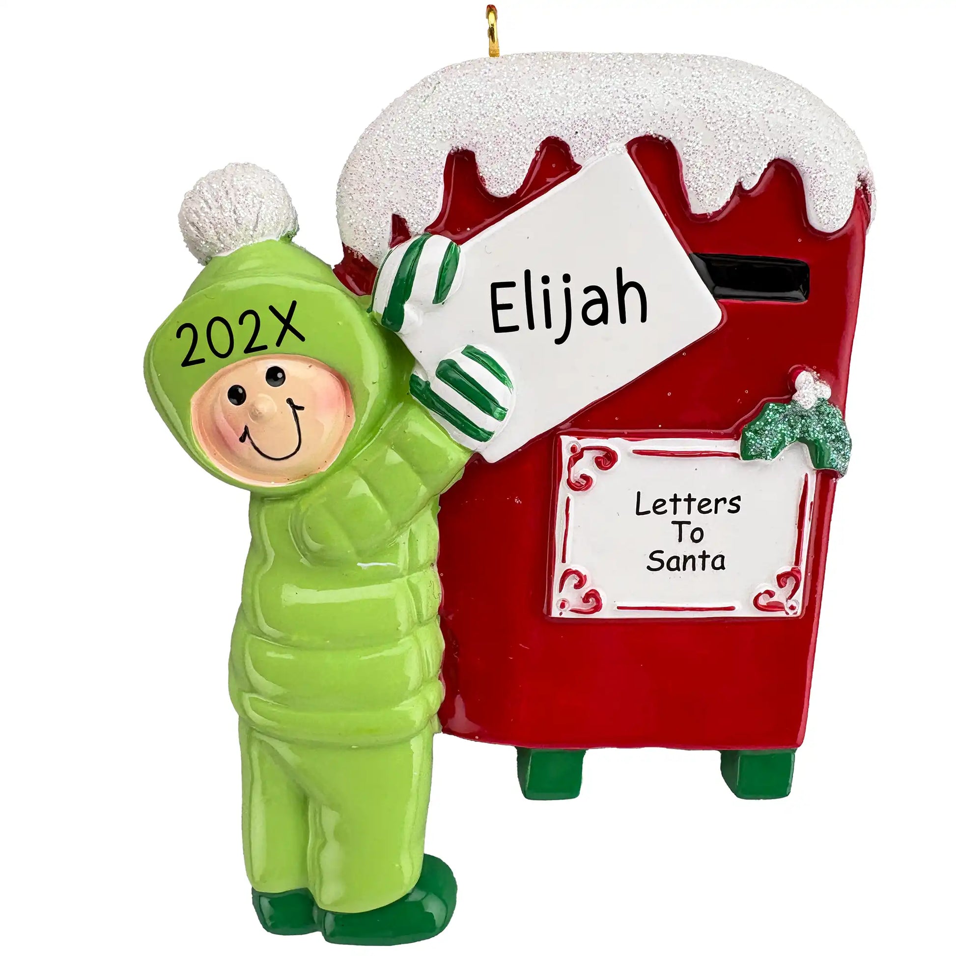 A personalized Christmas ornament of a child in a green snowsuit mailing a letter to Santa in a red mailbox, with space for a custom name.