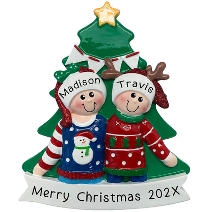 Personalized Christmas ornament with two people in front of a Christmas tree, wearing Christmas sweaters.