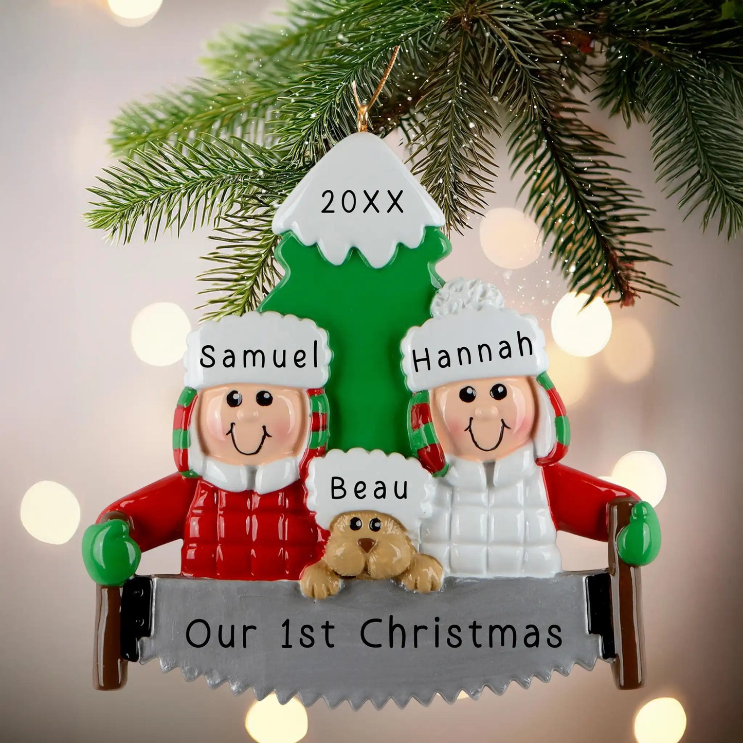 A personalized resin ornament featuring a couple in winter clothing with a dog, standing in front of a Christmas tree. The ornament includes customizable text for names and a year. The ornament is attached to a Christmas tree with a festive look.