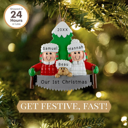 A personalized resin ornament featuring a couple in winter clothing with a dog, standing in front of a Christmas tree. The ornament includes customizable text for names and a year. The ornament is attached to a Christmas tree with a festive look.