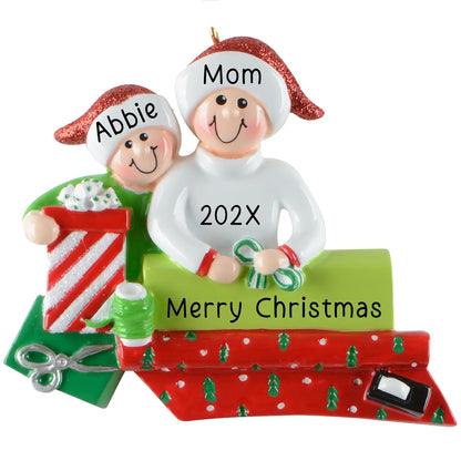 Personalized single parent and child Christmas ornament with gift wrapping scene, ribbon, scissors, and banner area for custom names and year