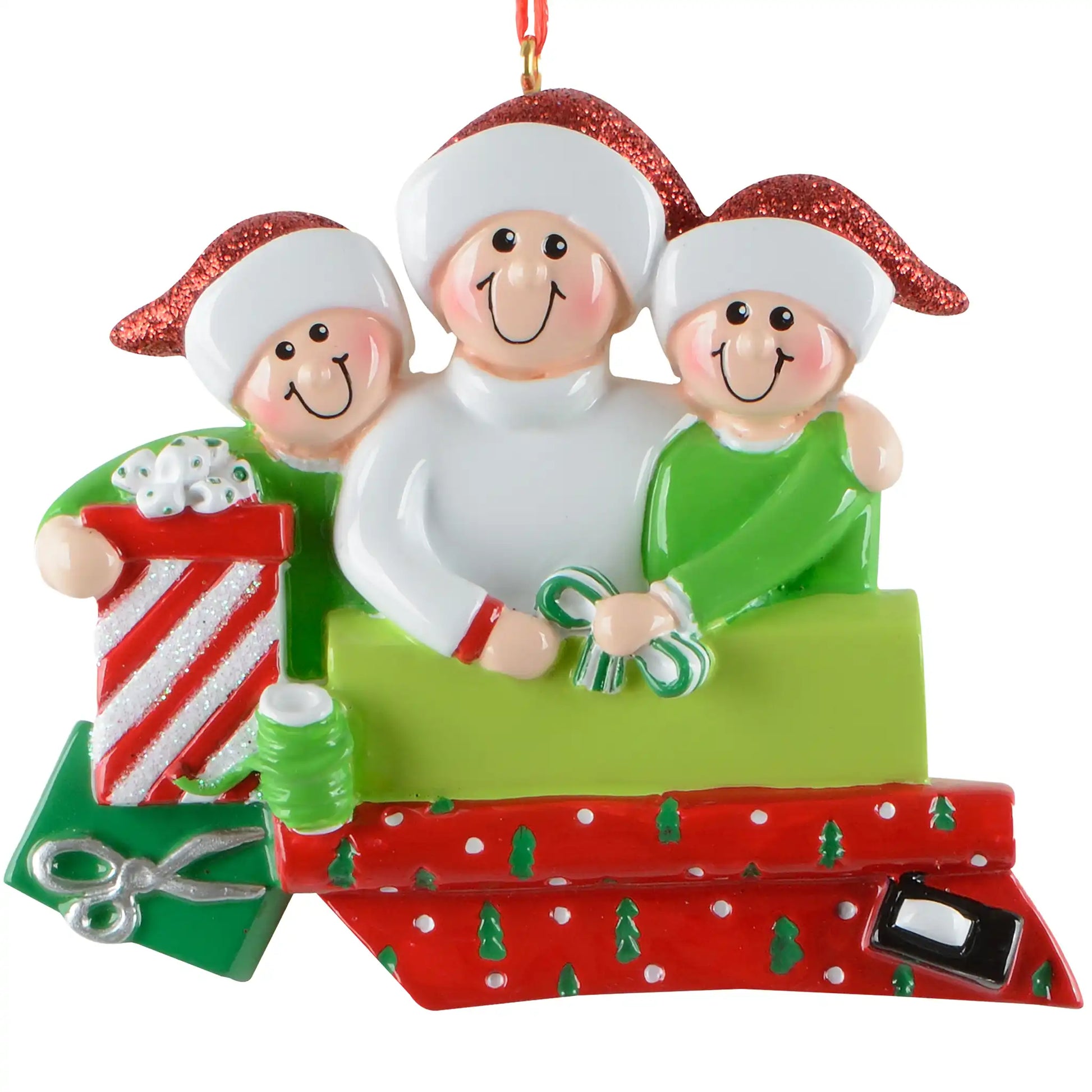 A personalized Christmas ornament of three people in Santa hats wrapping holiday gifts, featuring a green box for custom engraved names.