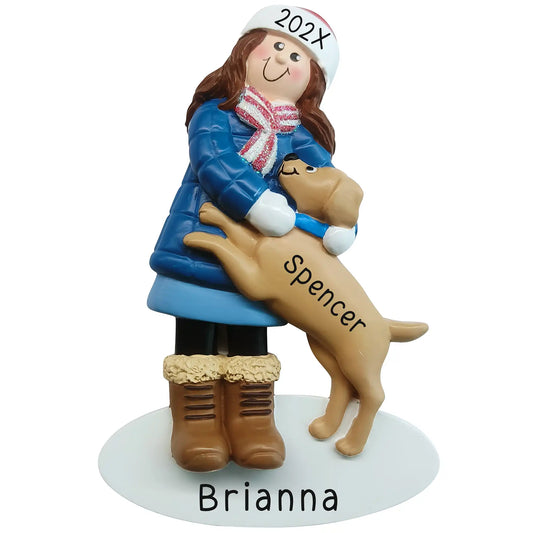 Personalized girl with dog Christmas ornament, a girl in a blue winter coat with her dog jumping into her arms, engraved Brianna on the base and Spencer on the dog