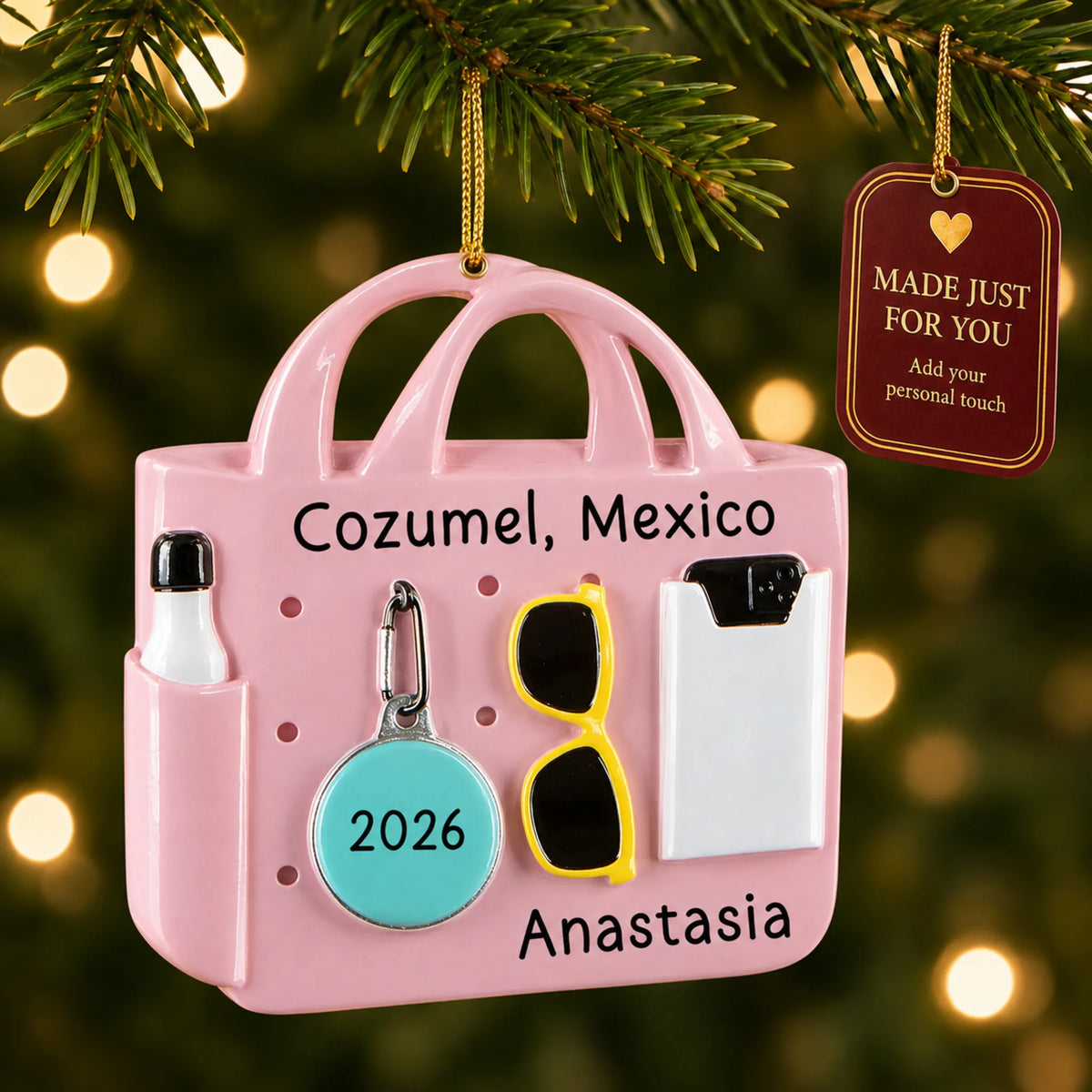 Pink beach bag christmas ornament hanging on a lit Christmas tree with a Made Just For You gift tag