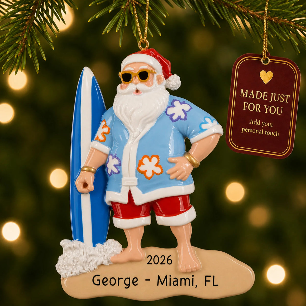 Surfing Santa christmas ornament hanging on a lit Christmas tree with a Made Just For You gift tag