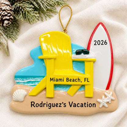 Personalized Adirondack chair and surfboard christmas ornament laid on a soft white knit blanket