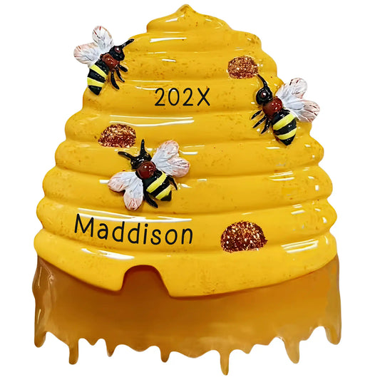 Personalized beehive Christmas ornament, a honey-dripping skep hive with three bees, engraved with the name Maddison and the year