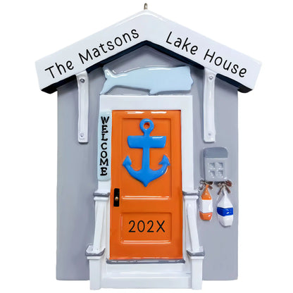 Personalized lake house Christmas ornament, a coastal house door with a blue anchor, welcome sign, and whale, engraved The Matsons Lake House with the year