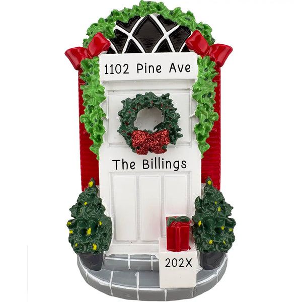 Personalized white front door Christmas ornament decorated with garland, red bows, wreath, potted trees and gift