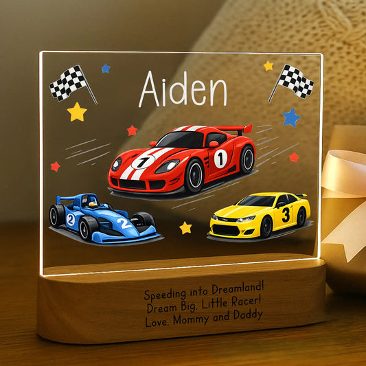 Personalized race car night light glowing with custom name Aiden laser engraved on acrylic and Speeding Into Dreamland message laser engraved on acacia wood base.