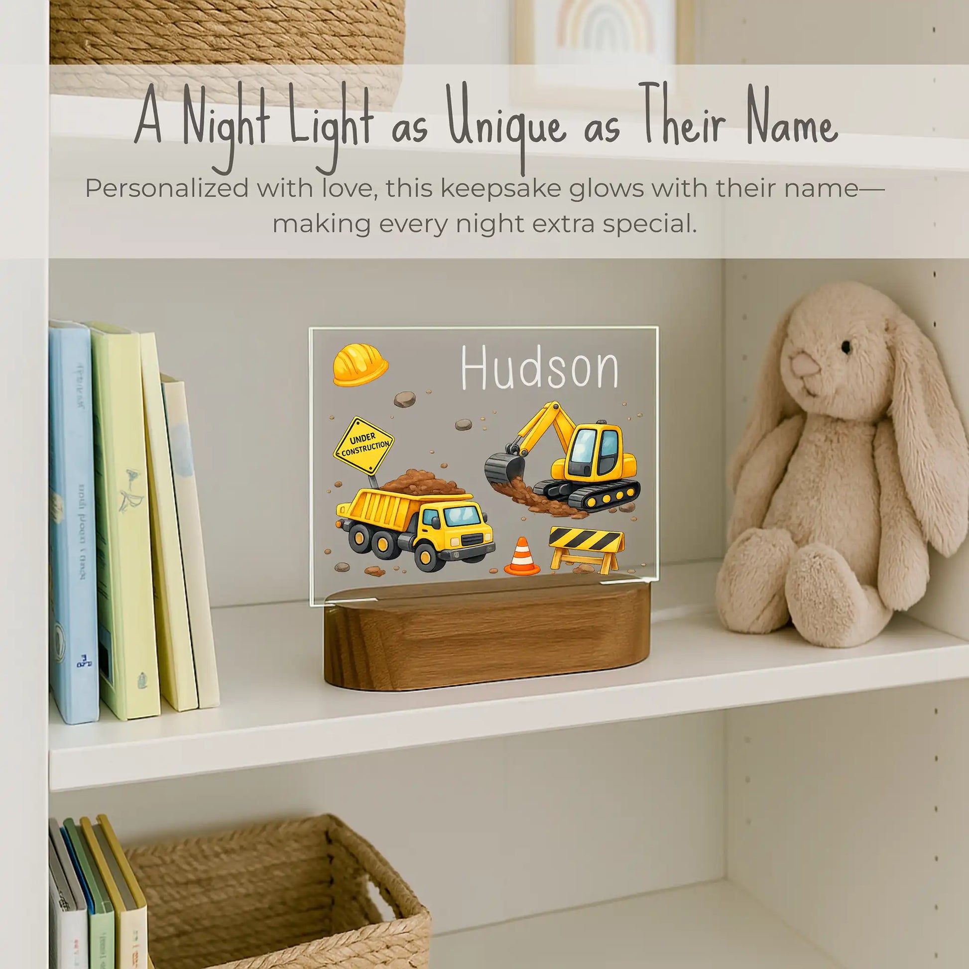Custom name construction night light sitting on kids bookshelf, acrylic plate with dump truck and excavator design, personalized with child's name, warm LED glow