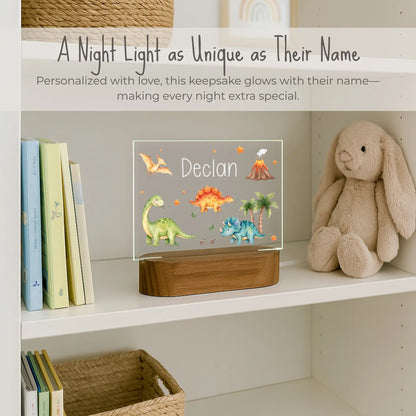 Personalized dinosaur night light styled on a nursery bookshelf beside a stuffed bunny and children's books