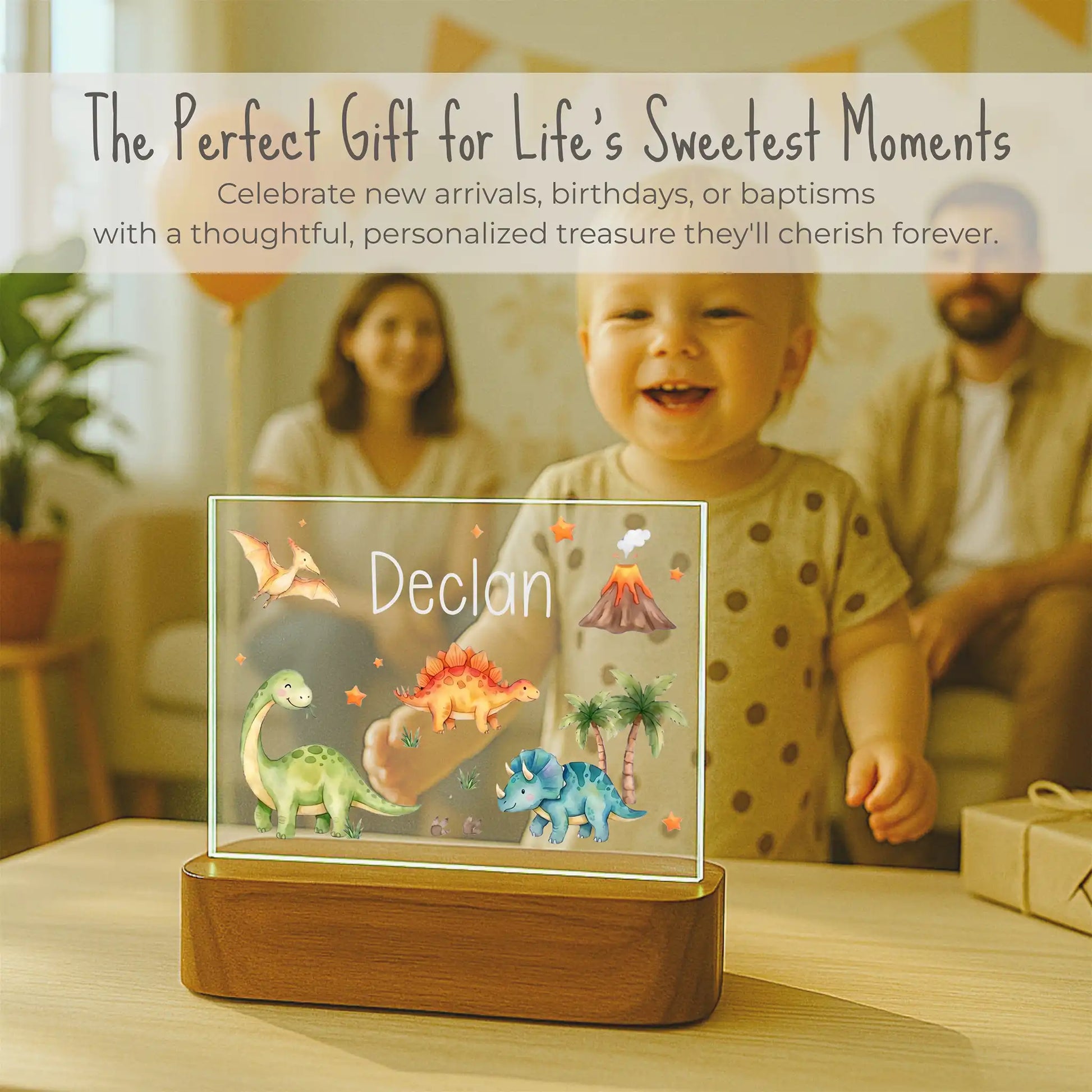 Decorative night light with dinosaur design and 'Declan' text, placed on a table with a family in the background.