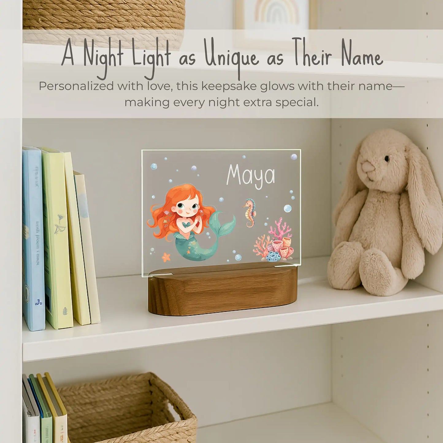 Custom name mermaid night light on girls bookshelf, acrylic plate with mermaid seahorse and coral design, personalized with child's name Maya, warm LED glow