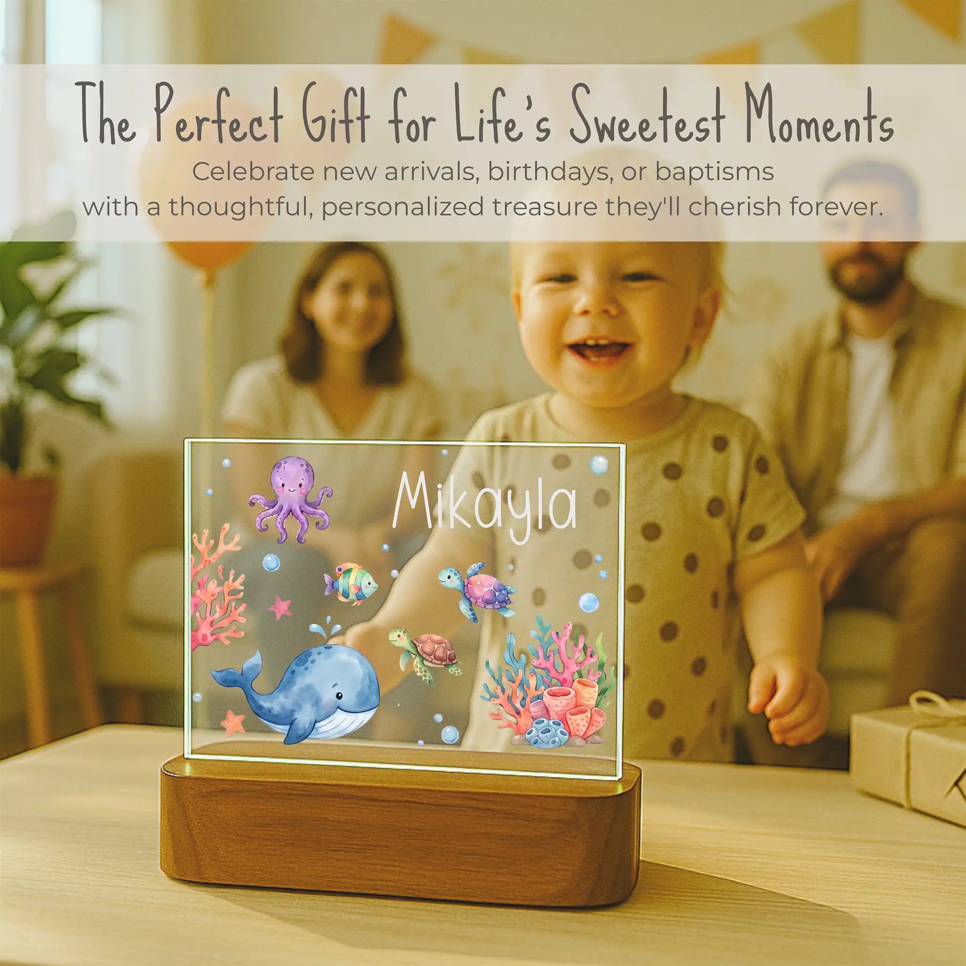 Children's night light with underwater design and 'Mikayla' on a table with family in the background.
