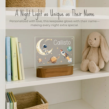Personalized space night light styled on a nursery bookshelf beside a stuffed bunny and children's books