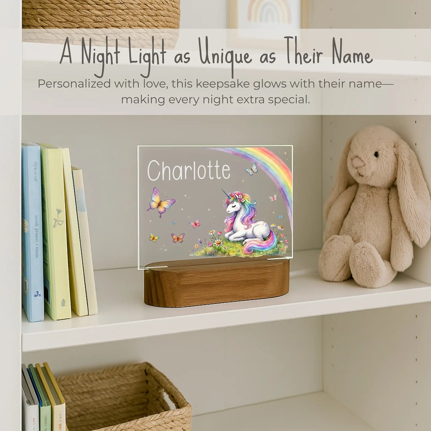 Custom name unicorn night light on girls bookshelf, acrylic plate with unicorn rainbow and butterfly design, name Charlotte laser engraved, warm LED glow on acacia wood base