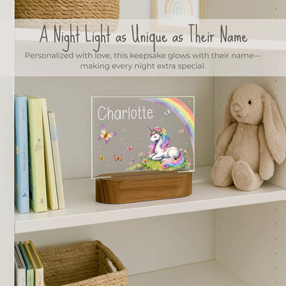 Custom name unicorn night light on girls bookshelf, acrylic plate with unicorn rainbow and butterfly design, name Charlotte laser engraved, warm LED glow on acacia wood base