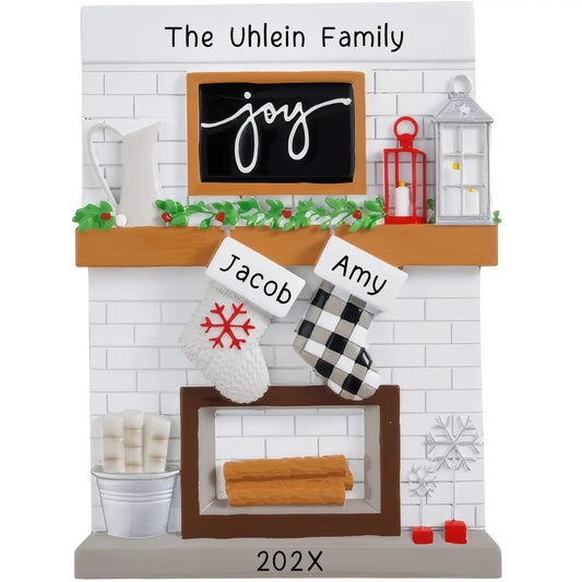 A table top ornament featuring a fireplace mantle with two customizable stockings, personalized with the names 'Jacob' and 'Amy' and the year '202x'.