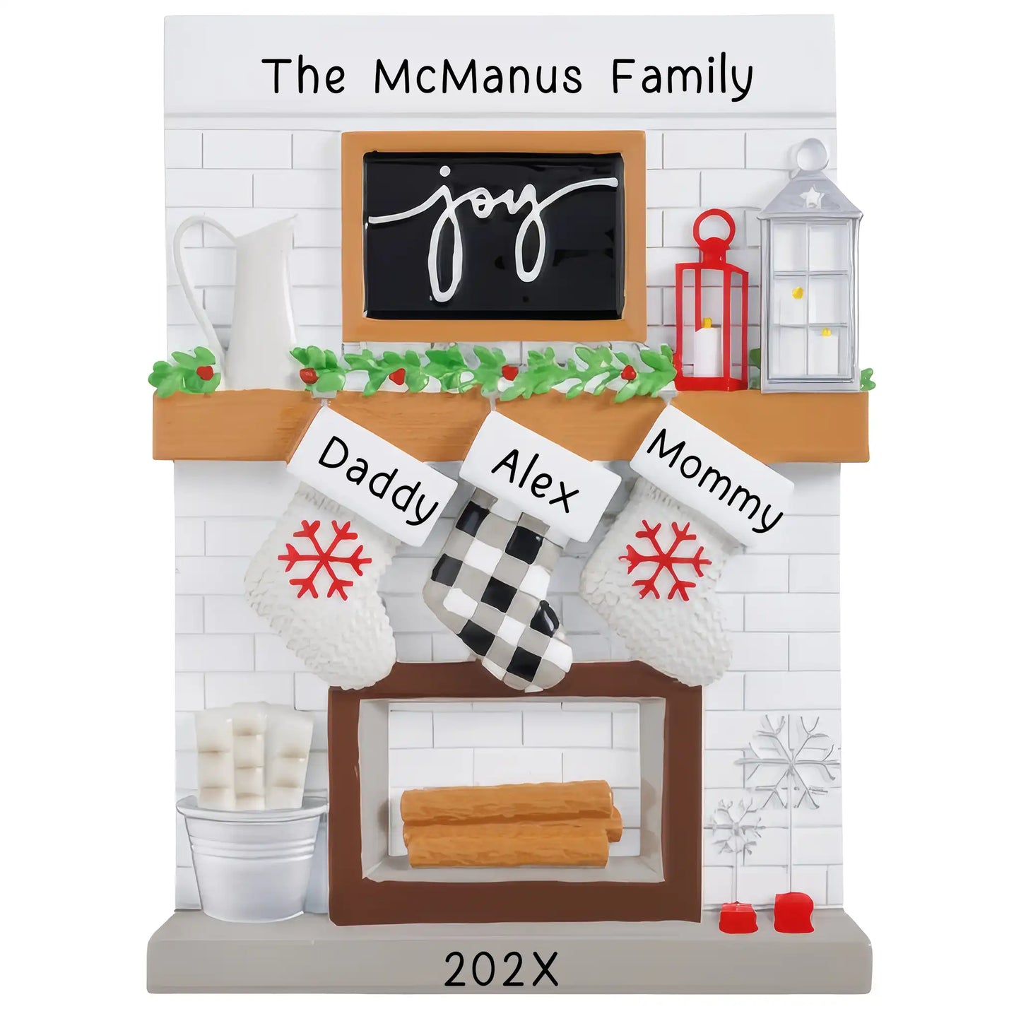 A table top Christmas ornament featuring a fireplace mantle with three customizable stockings. The ornament has a 'The McManus Family' text above the fireplace, and each stocking can be personalized with names and a year below.