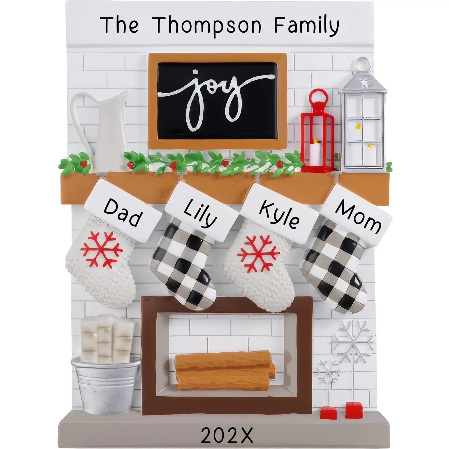 A resin fireplace mantle tabletop decoration featuring stockings with the names 'Dad', 'Mom', and 'Kids' and the word 'Joy' on the mantle, along with Christmas decorations and a personalized touch.