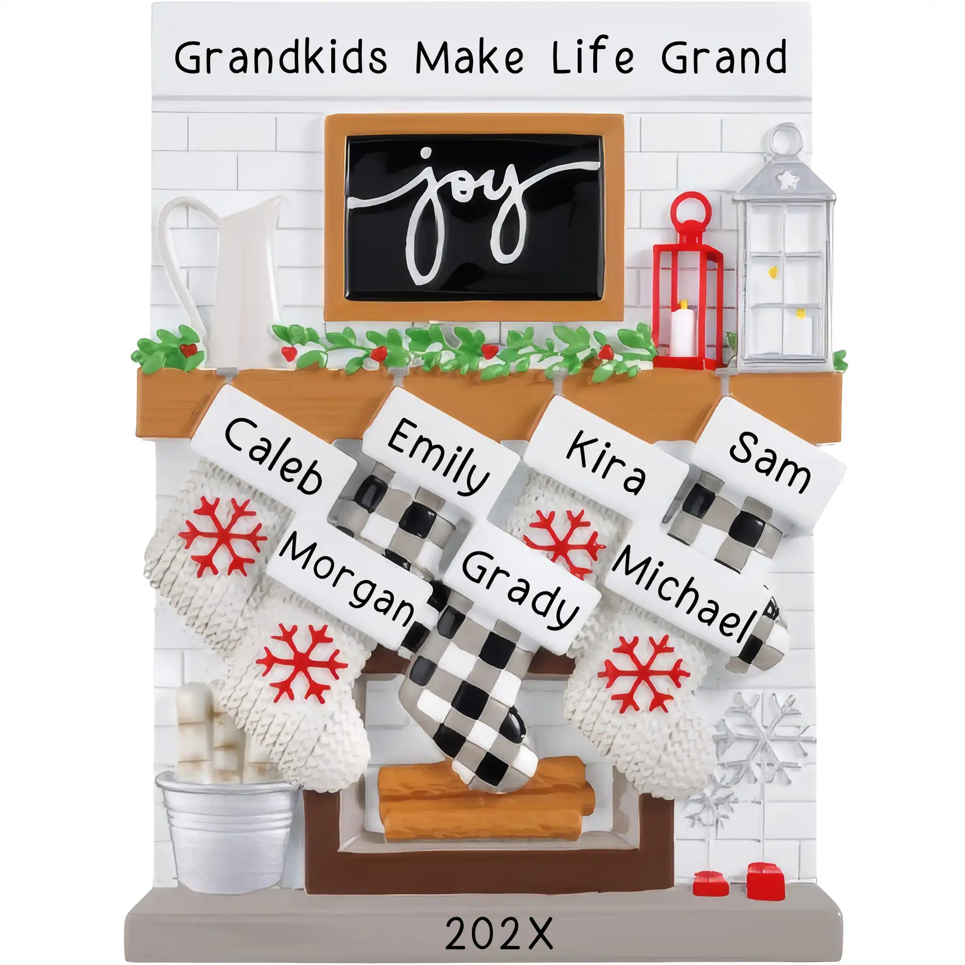 A table top Christmas ornament featuring a fireplace mantle with eight customizable stockings, each labeled with names. The background has a festive pattern with snow and gifts.