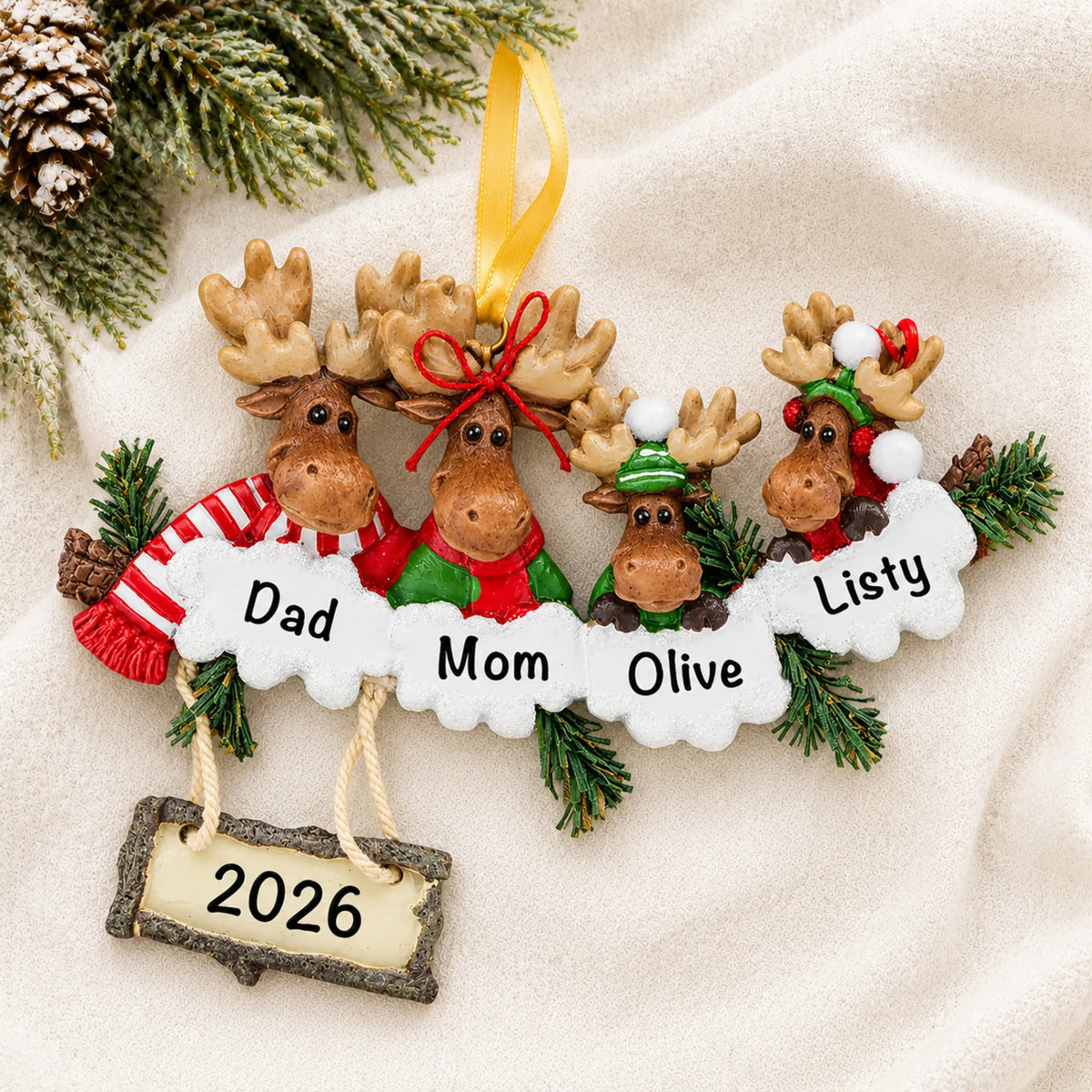 Personalized moose family of 4 christmas ornament laid on a soft white knit blanket